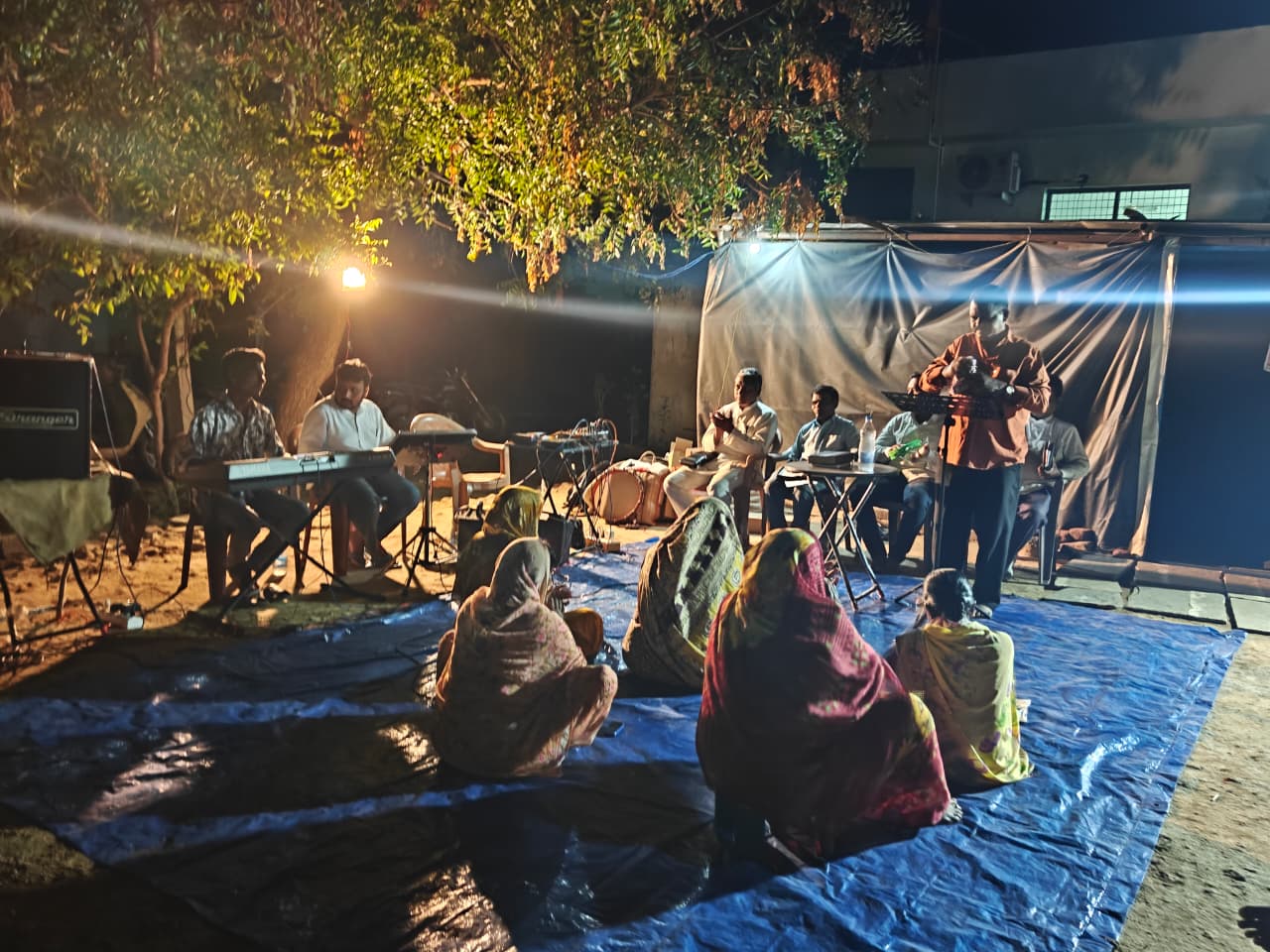 Home prayer meeting with believers gathered at night.