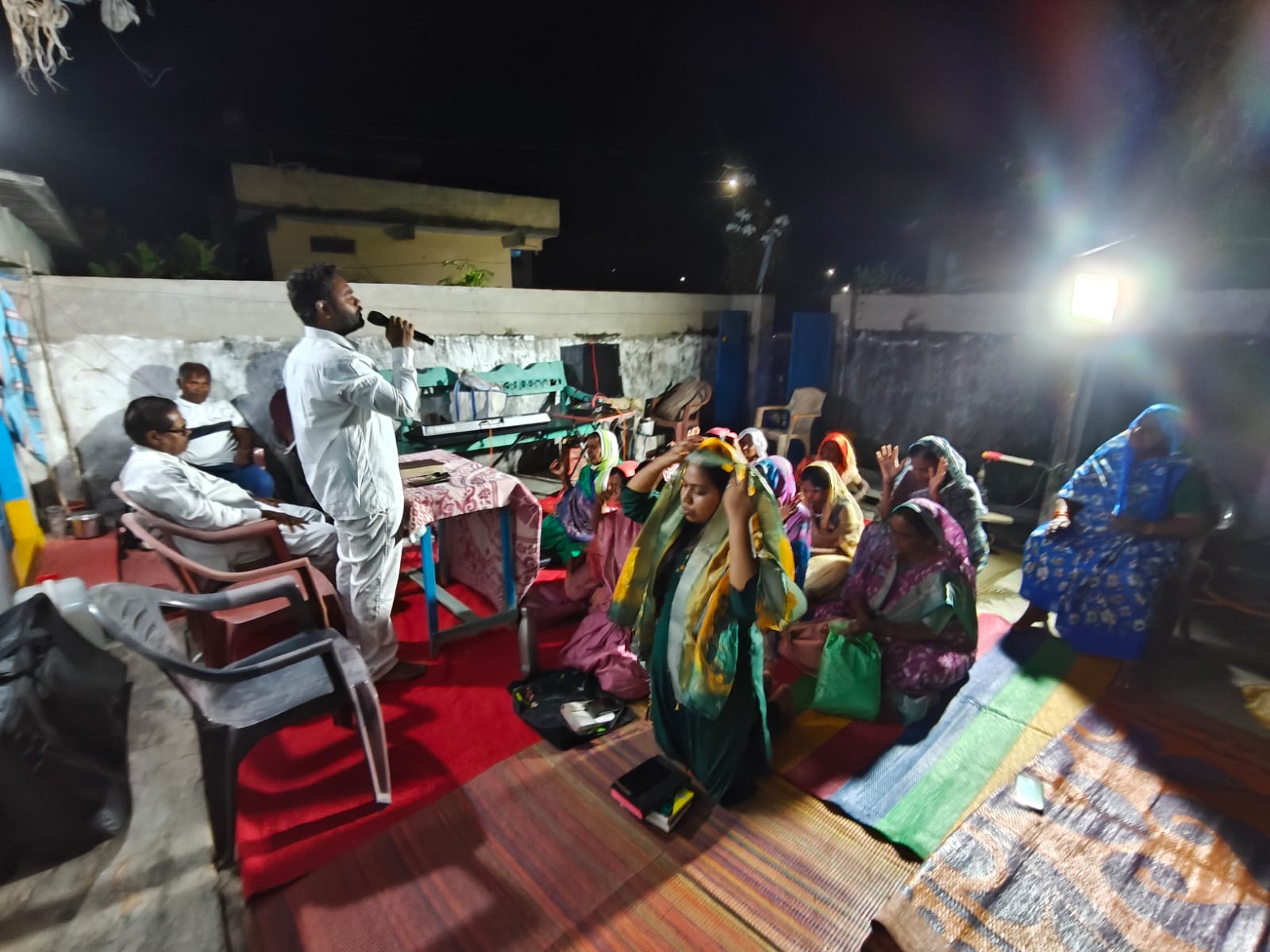 Night prayer meeting with church members gathered in worship.